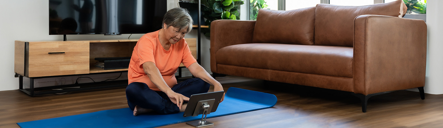 person watching tablet on yoga mat
