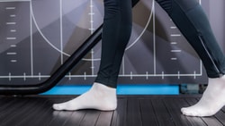 Person with white socks and black pants walking on treadmill; graphic pattern background. #medbridge.