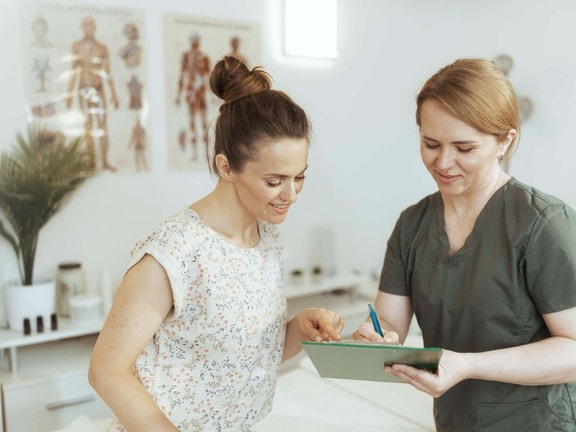 Healthcare professional reviewing digital patient feedback data on a tablet to improve clinical quality.