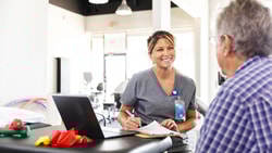 Occupational therapist reviewing notes with patient using an OT documentation cheat sheet PDF in a clinic setting