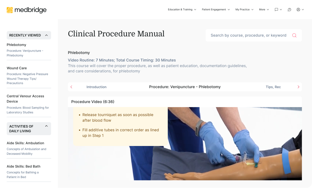 A medbridge phlebotomy training video plays on a computer, showing venipuncture on a practice arm with on-screen instructions.