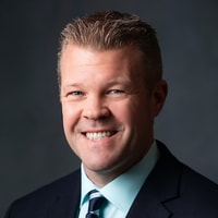 A confident man in a suit and striped tie represents digital healthcare innovation for medbridge.