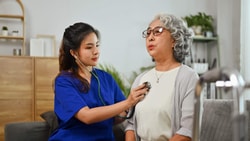 Clinician assessing older adult with stethoscope, highlighting cardiovascular disease care in an acute setting.