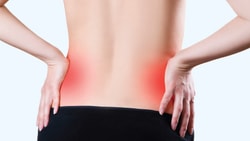 Person clutching sore lower back highlighted in red.