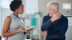 Clinician reviewing remote patient monitoring (RPM) data with older patient during outpatient visit