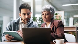 physical therapists in office reading new APTA report