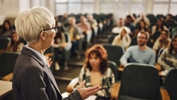 An instructor speaking to a group in a classroom, showing how voice is used in everyday professional work.