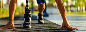 Runner with a prosthetic leg at the starting line on an outdoor track, reflecting medbridge's impact in digital healthcare.