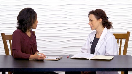 Two women discuss digital healthcare advancements, one in a white coat and the other with a medbridge clipboard.