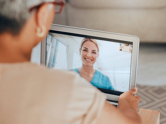 Patient participating in telerehabilitation video visit with physical therapist on tablet at home