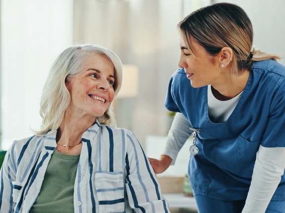 Home health professional engaging with an older adult patient as part of compliant, patient-centered home care.