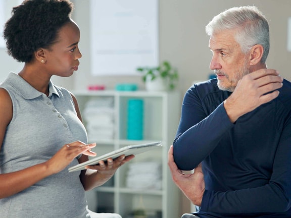 Clinician reviewing remote patient monitoring (RPM) data with older patient during outpatient visit