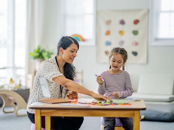 SLP working with young child on labeling activities to build tacts in speech-language therapy.