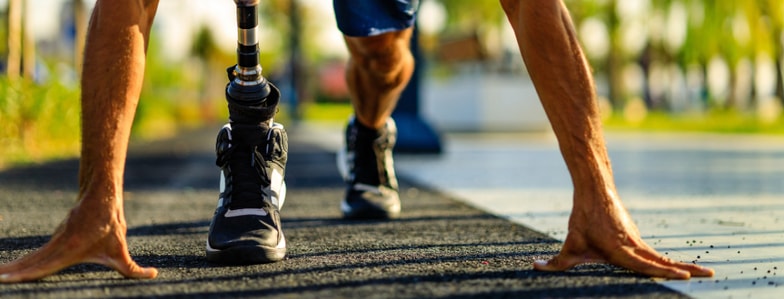 Runner with a prosthetic leg at the starting line on an outdoor track, reflecting medbridge's impact in digital healthcare.