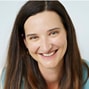 Individual with long brown hair, smiling in a light blue top, on a plain white background for medbridge.
