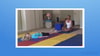 In a training room, one person lies on an exercise mat while another sits cross-legged nearby, demonstrating healthcare skills for medbridge.