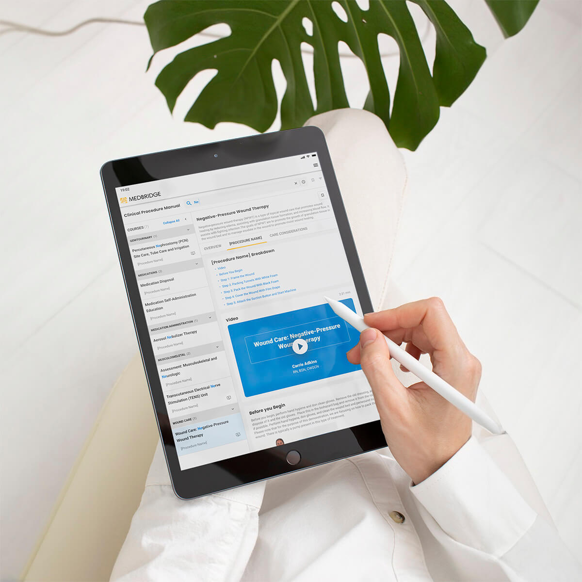 A person uses a stylus on a tablet to browse a Medbridge medical website about pressure wound therapy.