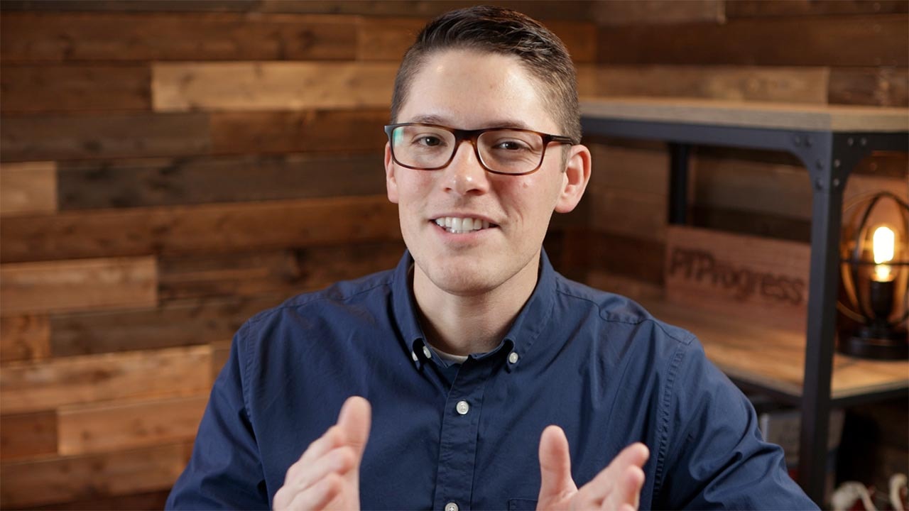 A person in glasses and a blue shirt gestures in a healthcare education setting with medbridge resources.