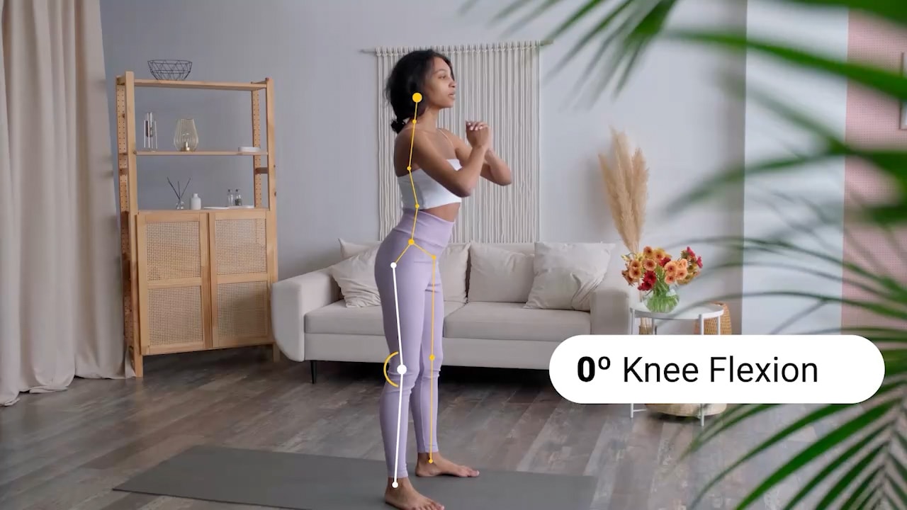 A woman demonstrates a standing exercise with body alignment lines and "0° Knee Flexion" highlighted in a living room, for medbridge.