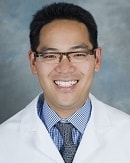 A smiling person in glasses and a white medical coat represents Medbridge's digital healthcare future.