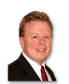 Smiling man in a suit and tie representing healthcare education confidence for medbridge.