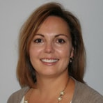 A smiling person in a gray sweater represents medbridge and the evolving landscape of digital healthcare.