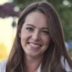 A smiling woman in a white shirt embodies positivity and healthcare education in a green, outdoor setting for medbridge.