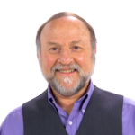 A bearded man in a purple shirt and dark vest smiles against a white background, representing enthusiasm for digital healthcare innovations like medbridge.