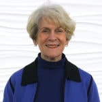 An older adult smiling in front of a wavy white background, representing Medbridge's patient care software expertise.
