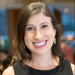 A smiling individual with brown hair and earrings, wearing a black top, embodies the warmth of hybrid care in medbridge's digital environment.
