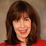 A smiling person with shoulder-length brown hair in a red top represents digital healthcare innovations by medbridge.