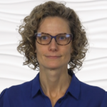A person with curly hair and glasses in a blue shirt represents the future of digital healthcare with medbridge.