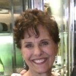 A smiling woman with short curly hair and earrings stands against a metallic and green backdrop, representing Medbridge's digital healthcare innovation.
