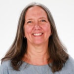 A smiling woman with long gray hair represents Medbridge's blend of human touch and digital healthcare against a white background.