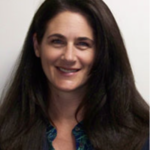 A smiling woman with long dark hair in a blue top represents dedication and compassion in healthcare education for medbridge.