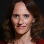 A woman with brown hair in a red top embodies Medbridge's hybrid healthcare education approach.