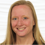 A smiling person with long blonde hair in a black top, symbolizing medbridge's digital healthcare innovation.