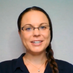 A smiling person with long brown hair, glasses, and a black shirt represents digital healthcare integration for medbridge against a light backdrop.