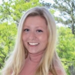 Person with long blonde hair smiling outdoors with trees behind, representing medbridge.