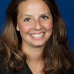 A person with long brown hair smiles in front of a blue background, representing Medbridge's digital healthcare innovation.