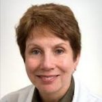 A person with short brown hair in a white coat smiles at the camera, representing medbridge's digital healthcare future.