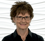 A person with short brown hair and glasses in a dark shirt symbolizes Medbridge's innovative digital and hybrid healthcare solutions.