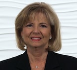 A confident person with short blonde hair in a black suit and diamond earrings represents the evolving digital healthcare landscape at medbridge.