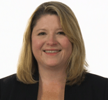A smiling individual with shoulder-length blonde hair in a black blazer represents medbridge's innovative digital healthcare solutions.
