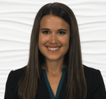 A person with long brown hair smiles in a dark blazer and teal top, representing modern digital healthcare for medbridge.