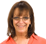 A smiling woman with brown hair, glasses, and a red blouse is pictured against a white background.