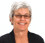 A smiling person with short gray hair and glasses in a dark blazer, symbolizing healthcare education excellence for medbridge.