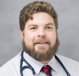 A bearded man in professional attire and stethoscope symbolizes Medbridge's vision for digital healthcare against a gray backdrop.