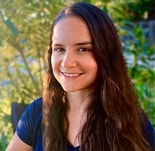 A smiling person with long brown hair sits outdoors among lush greenery, symbolizing medbridge's blend of nature and innovation.