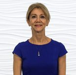 A woman in a blue dress smiles at the camera against a white textured background for medbridge.